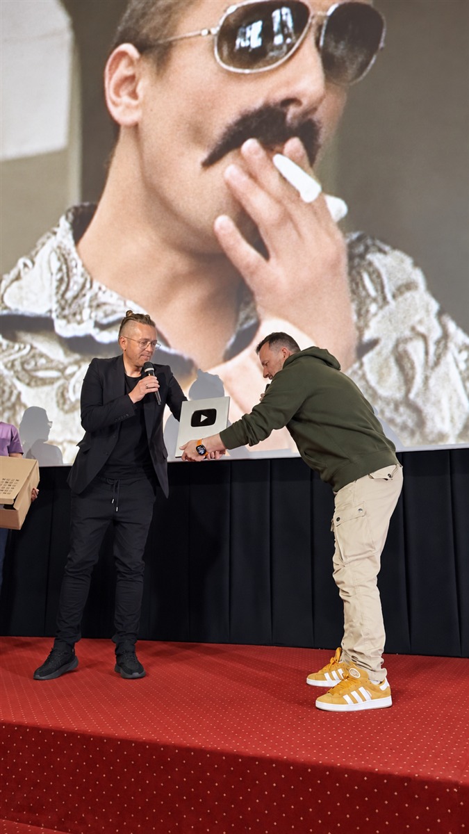 Bartosz Walaszek ogląda nagrodę YouTube prezentowaną przez Łukasza Skalika