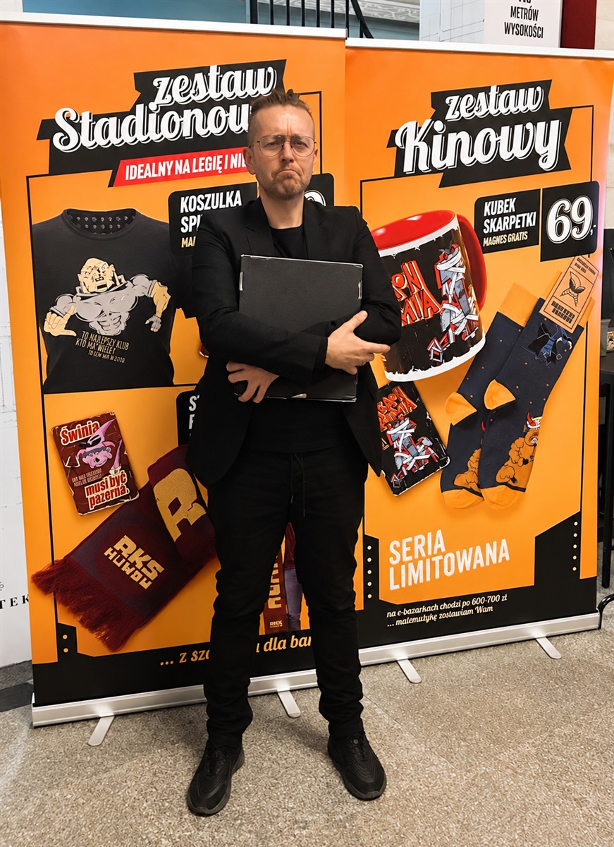 Łukasz Skalik z opakowaniem nagrody w holu Kinoteki